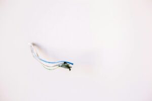 Loose electrical wires protruding from a white wall, ideal for home improvement concepts.