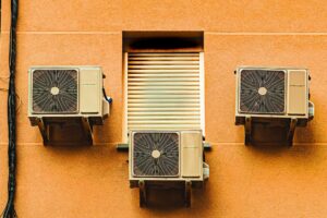 Exterior wall with three air conditioners, showcasing modern architectural elements.
