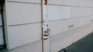 Close-up of a weathered drainpipe on an urban wall, showing signs of wear.