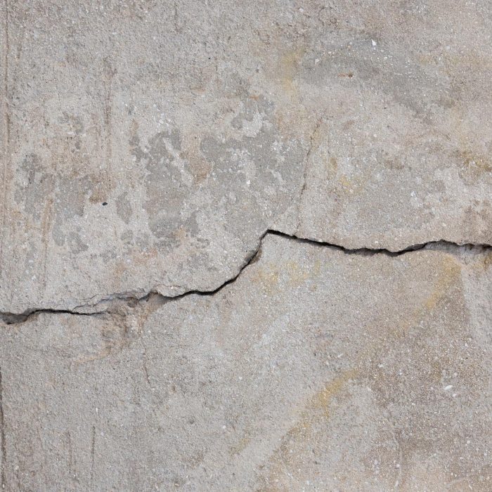 Detailed texture of a weathered concrete wall showing crack patterns.